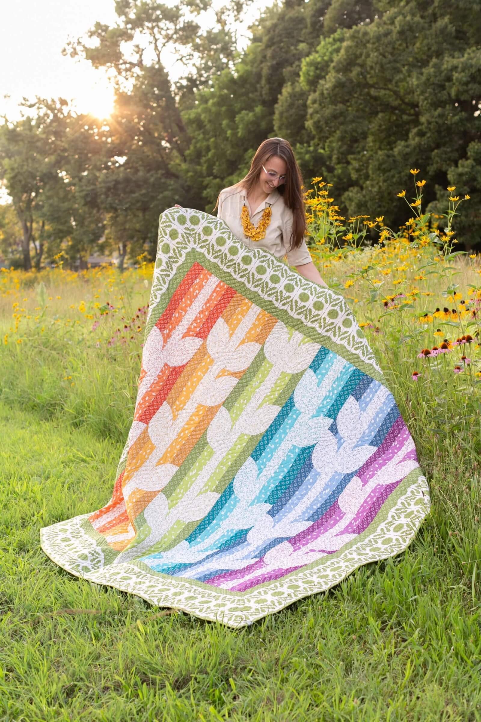 Rachel Rossi holding a colorful quilt